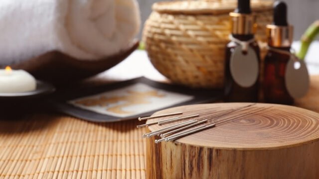 Composition with acupuncture needles on bamboo mat